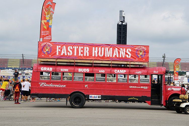 A red bus with a sign that says faster humans