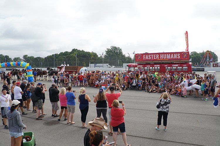 A large group of people are standing in a parking lot in front of a food truck.
