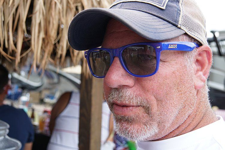 A man with a beard wearing sunglasses and a hat.