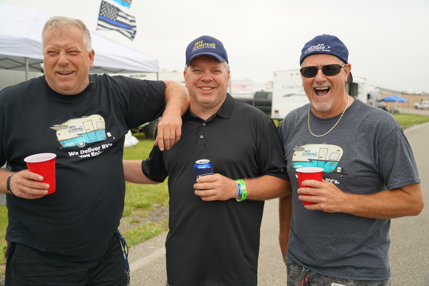 Three men are posing for a picture while drinking beer.