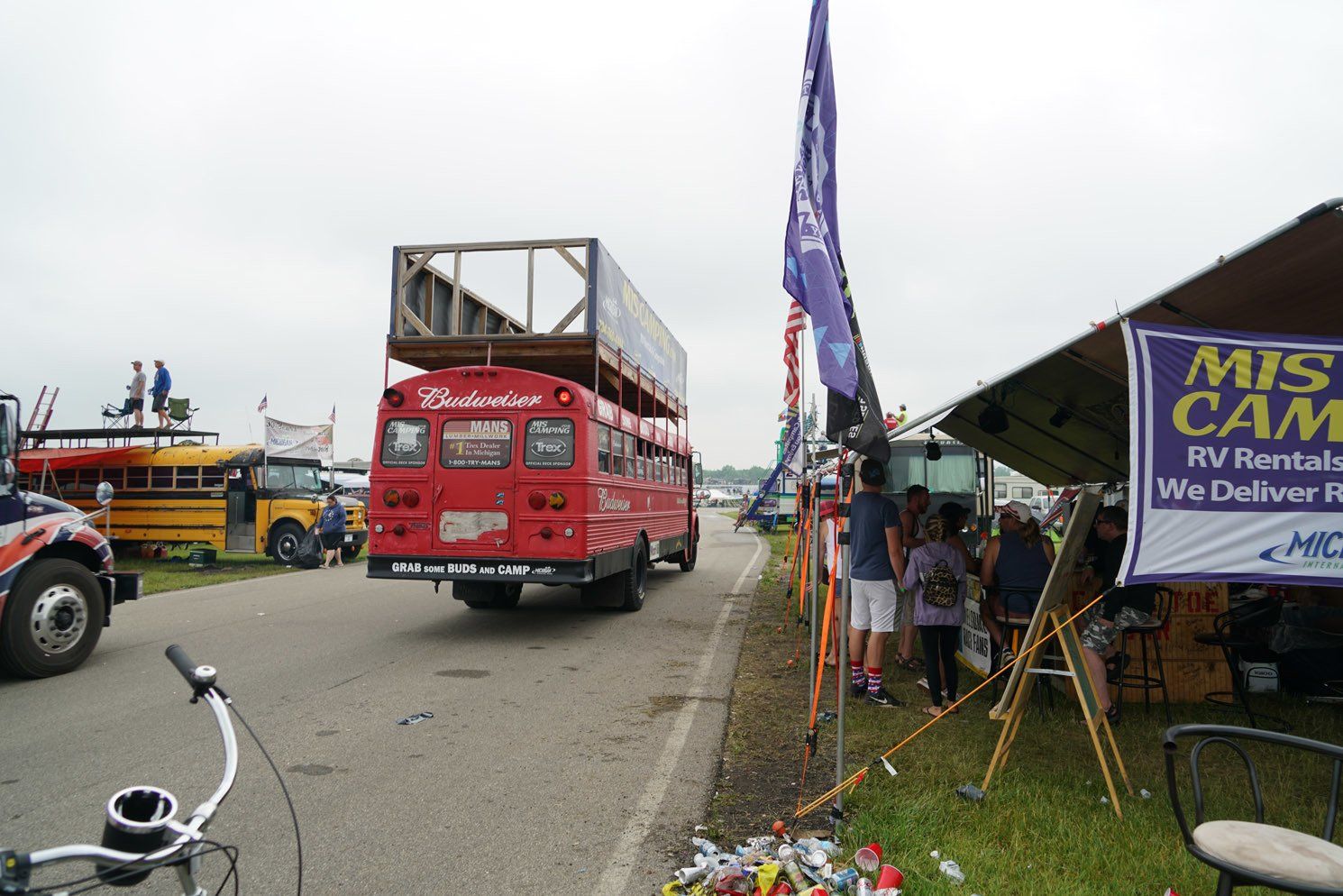 A red bus is parked next to a sign that says mis cam