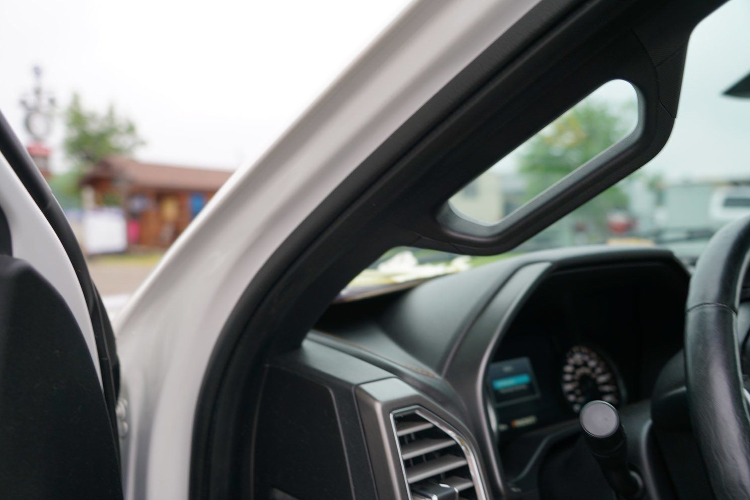 The inside of a white car with the door open