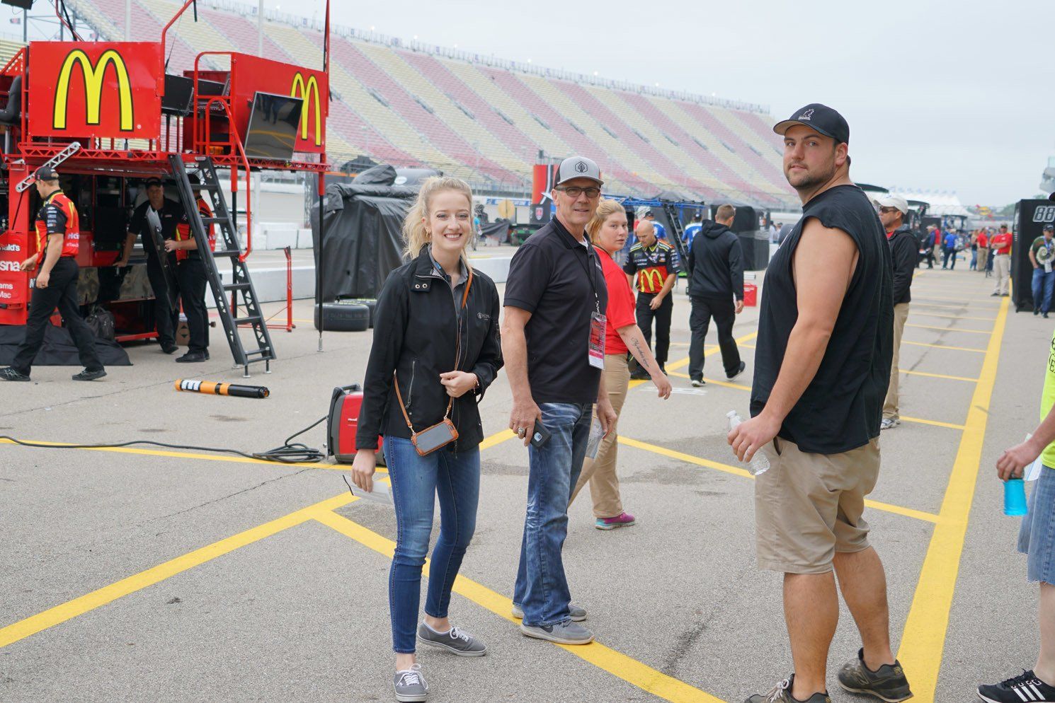 A group of people are standing in a parking lot in front of a mcdonald 's truck.