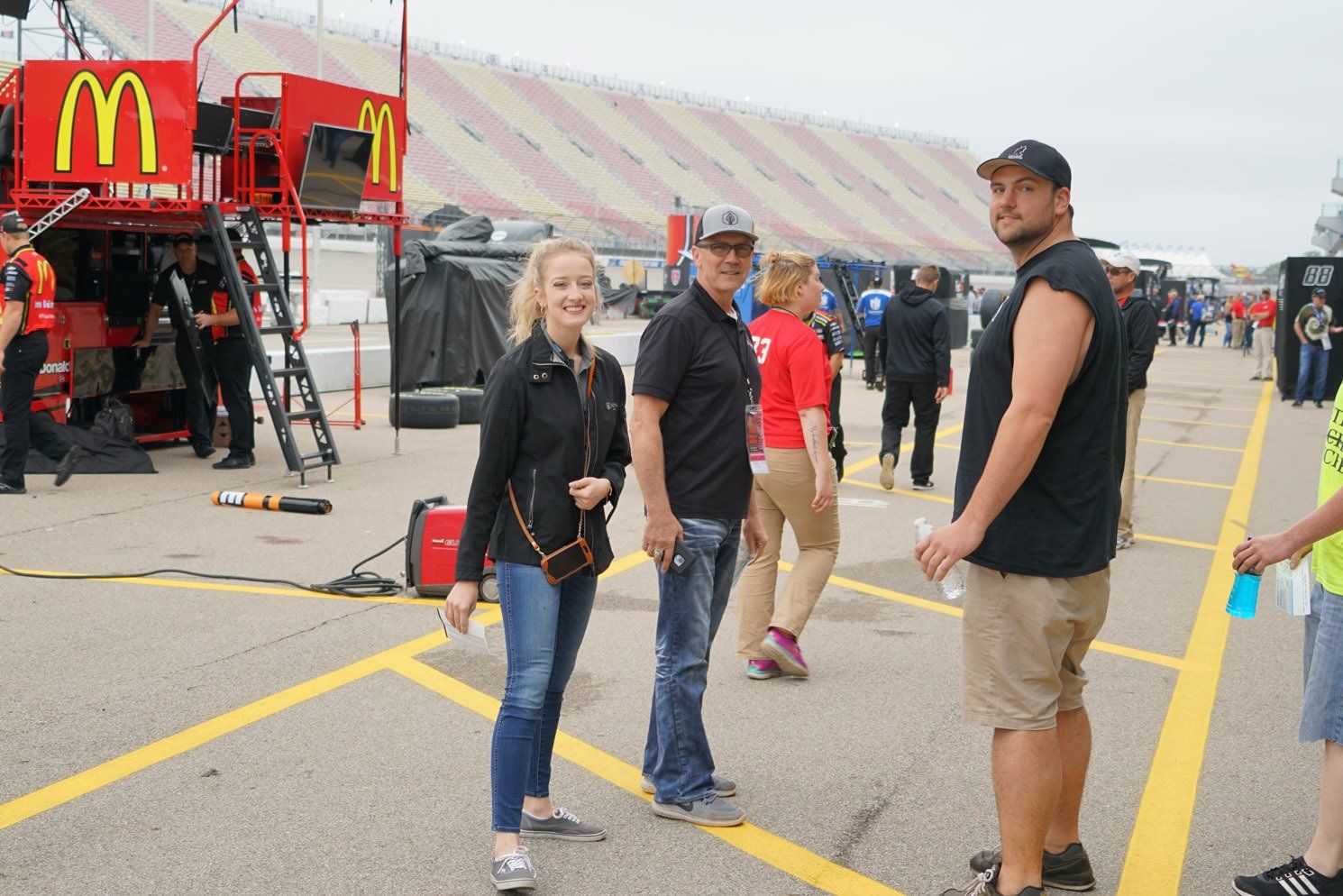 A group of people are standing in a parking lot in front of a mcdonald 's truck.