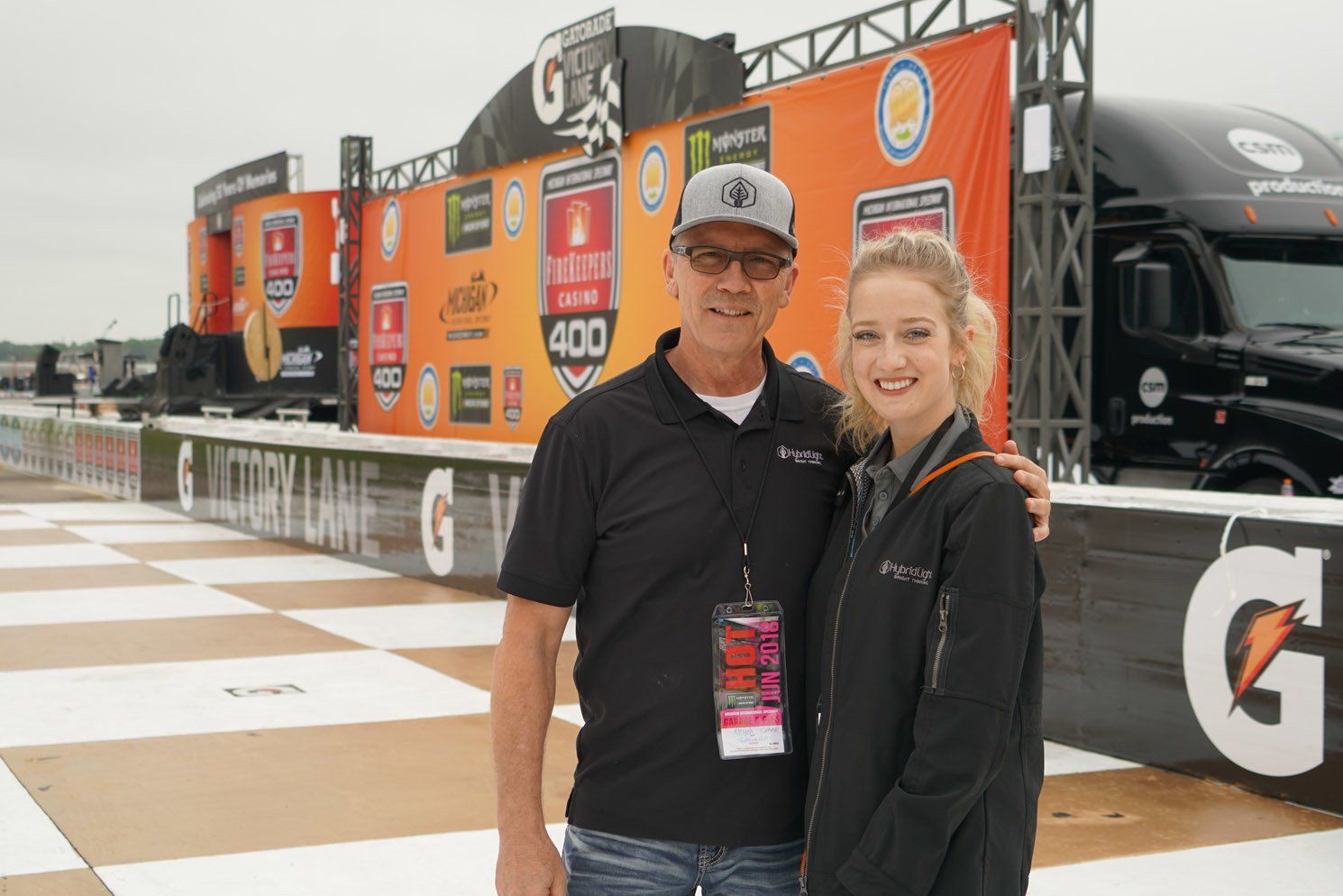 A man and a woman are posing for a picture in front of a gatorade sign.