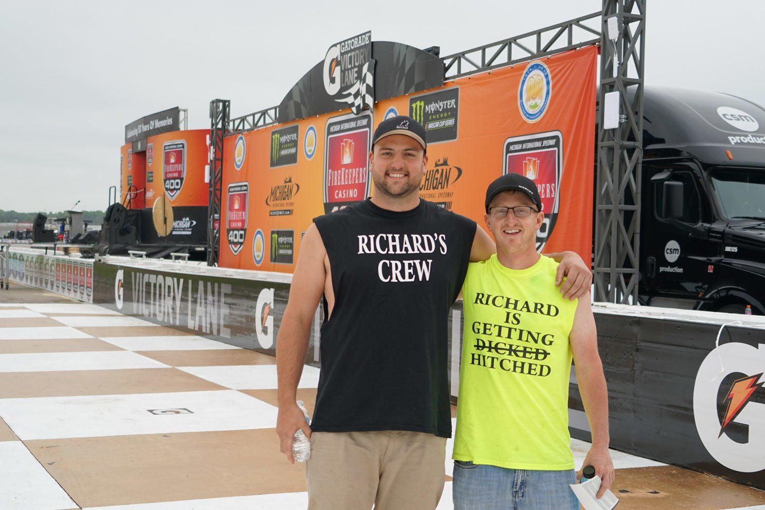 Two men posing for a picture with one wearing a shirt that says richard 's crew