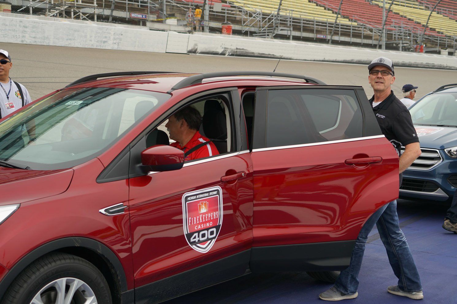 A man is pushing a red car with the word 400 on it