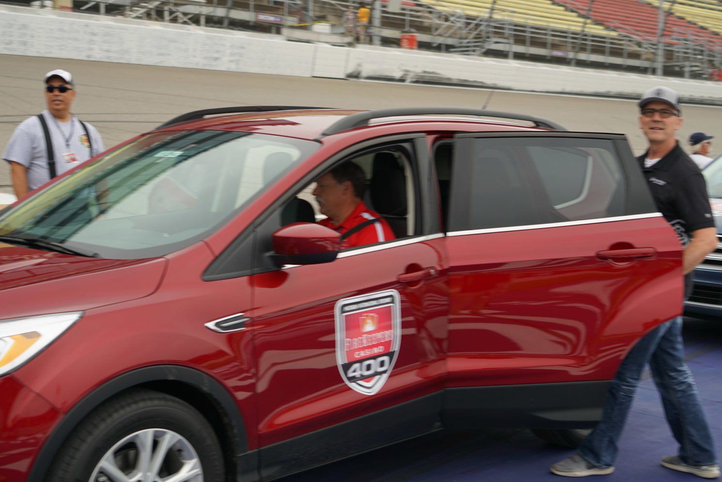 A man is getting out of a red car with the number 400 on the side