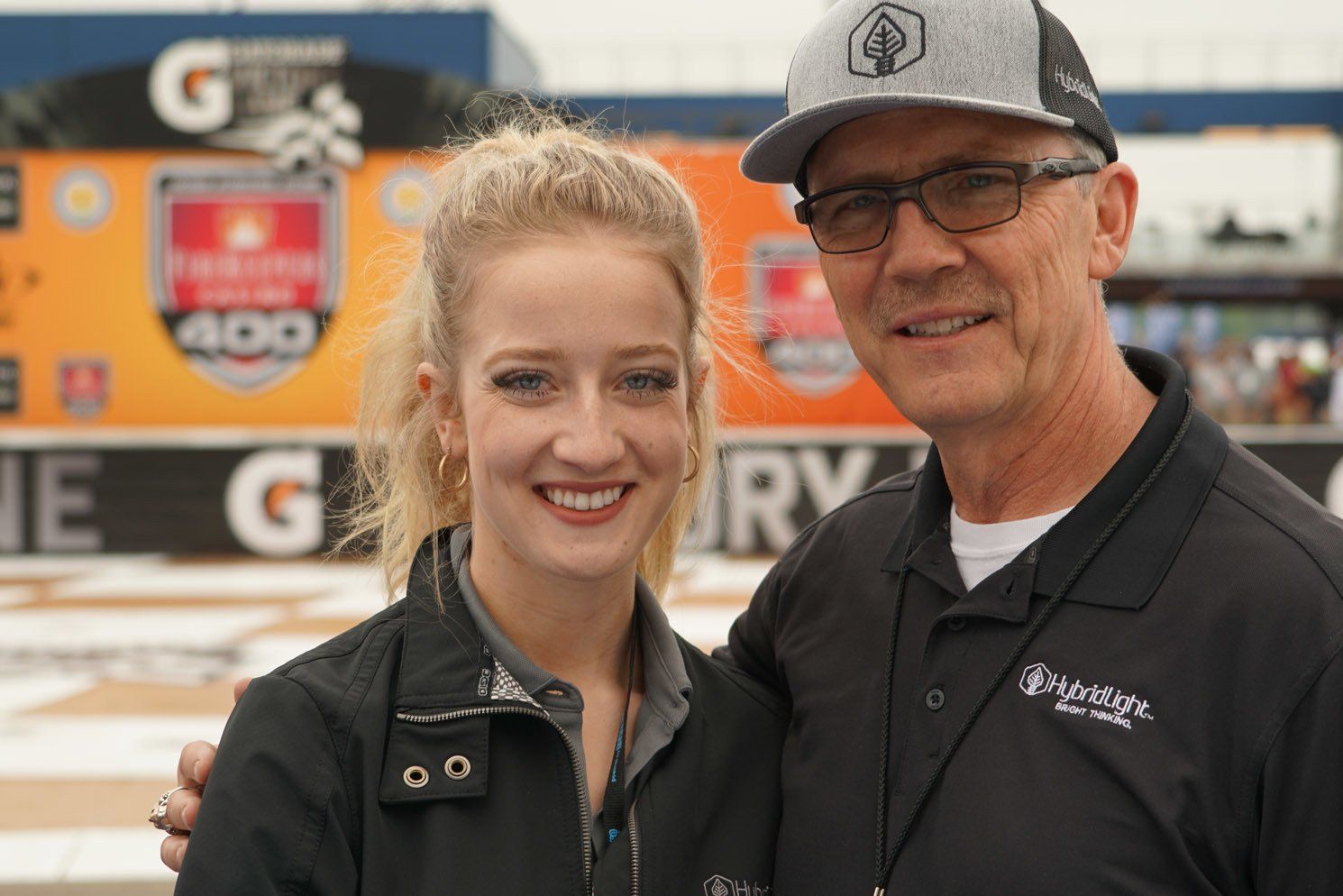 A man and a woman are posing for a picture in front of a gatorade sign