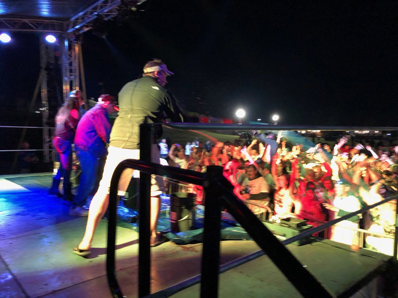 A man is standing on a stage in front of a crowd of people.