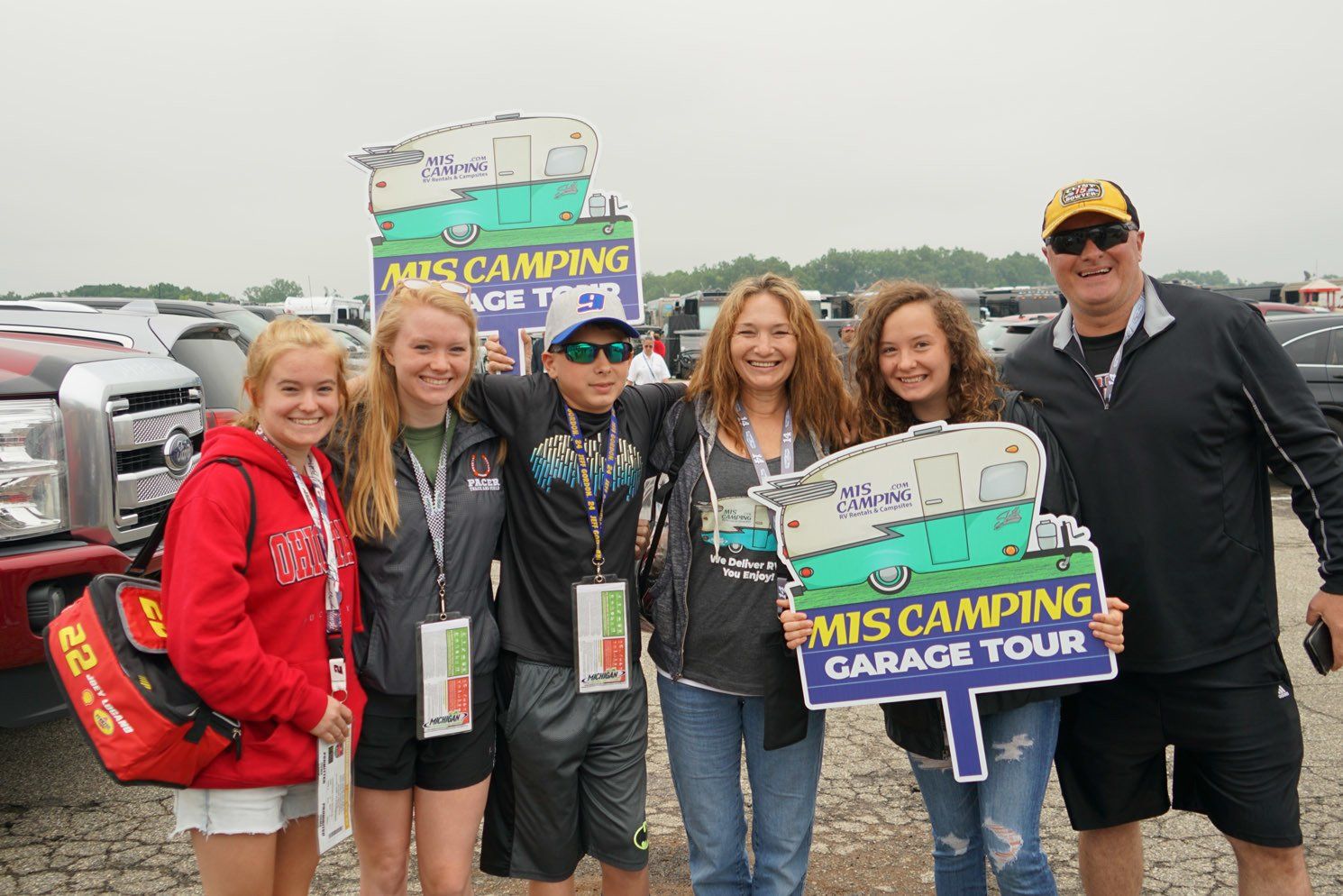 A group of people holding signs that say mis camping garage tour