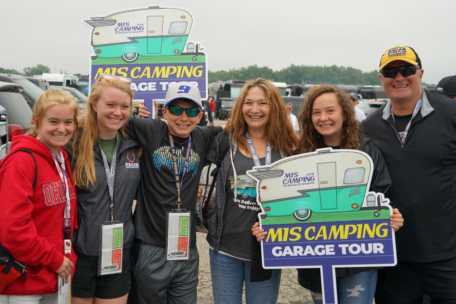 A group of people holding mis camping garage tour signs