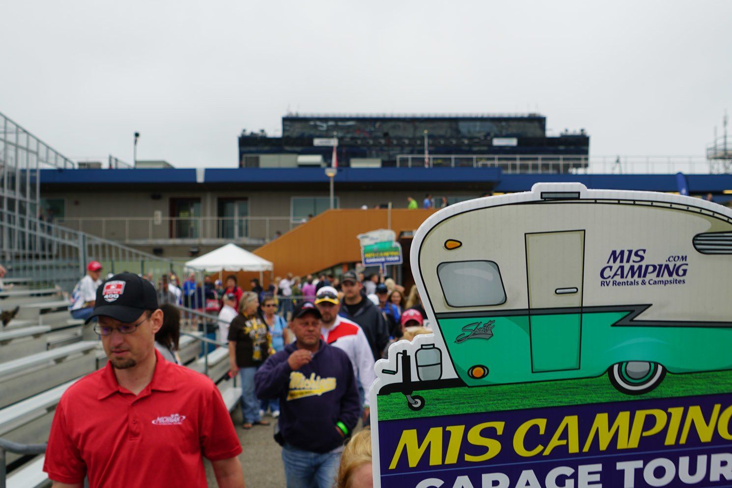 A man holding a sign that says mis camping garage tour