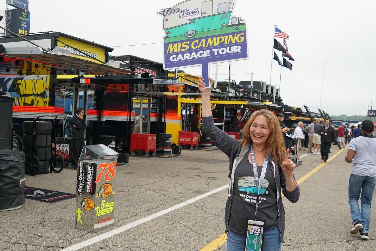 A woman is holding a sign that says mis camping garage tour