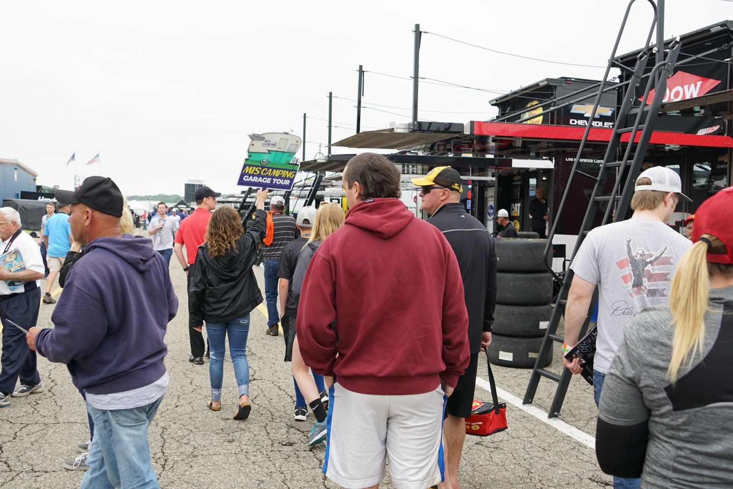A group of people are walking down a race track.