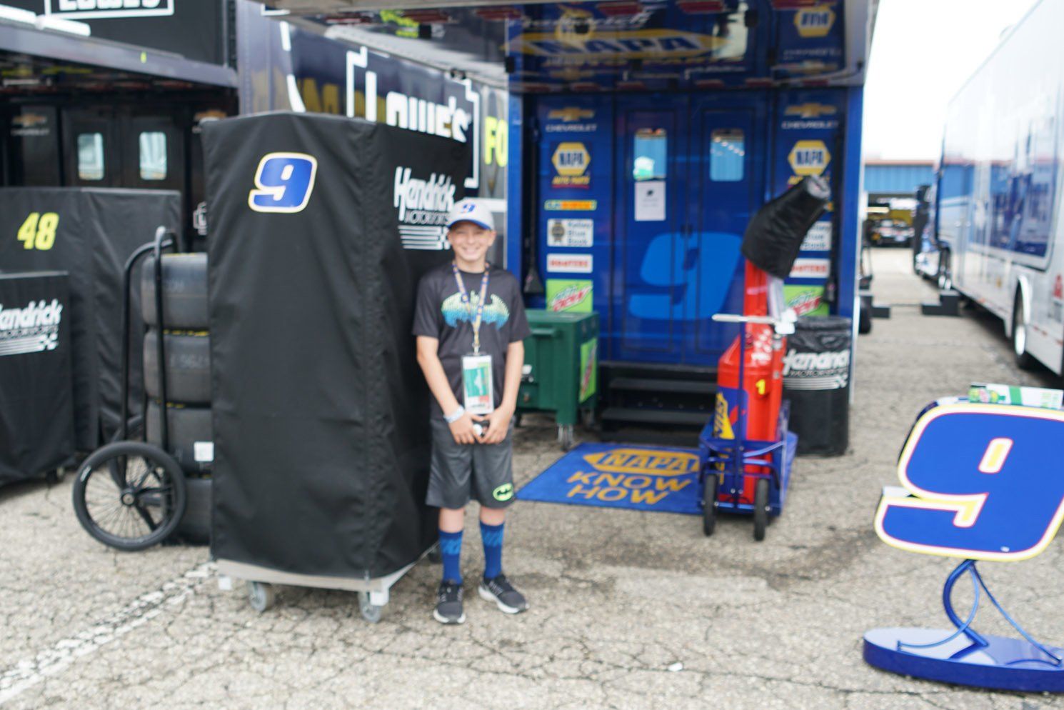 A young boy stands in front of a building with the number 9 on it