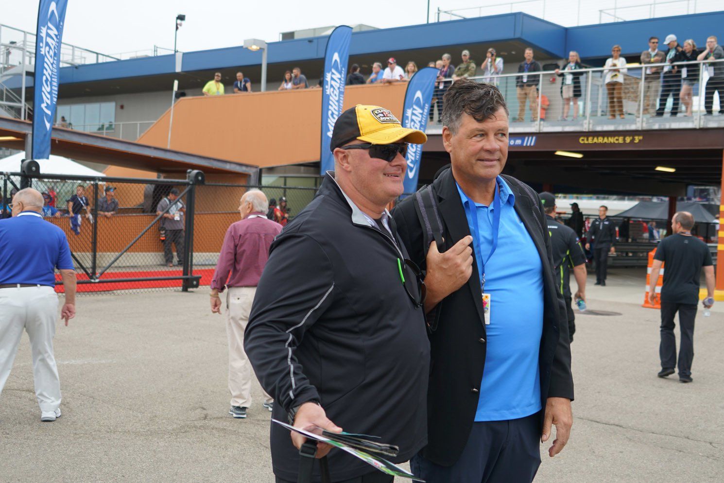 Two men are standing next to each other in front of a building