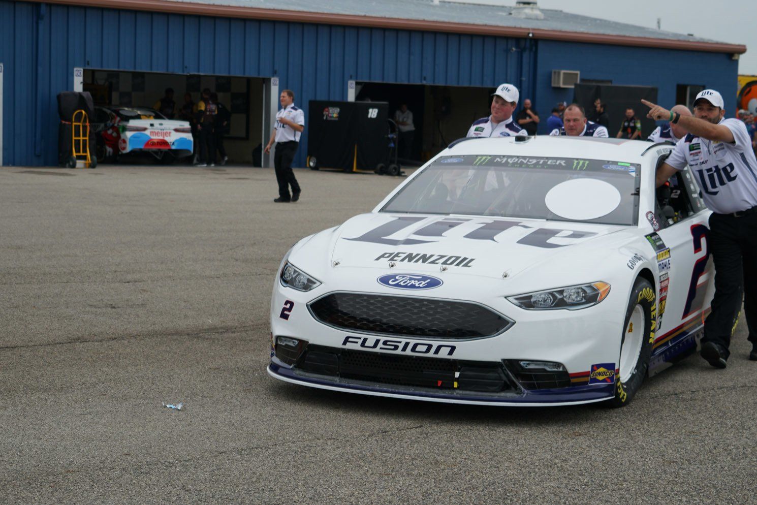 A race car is parked in front of a blue building
