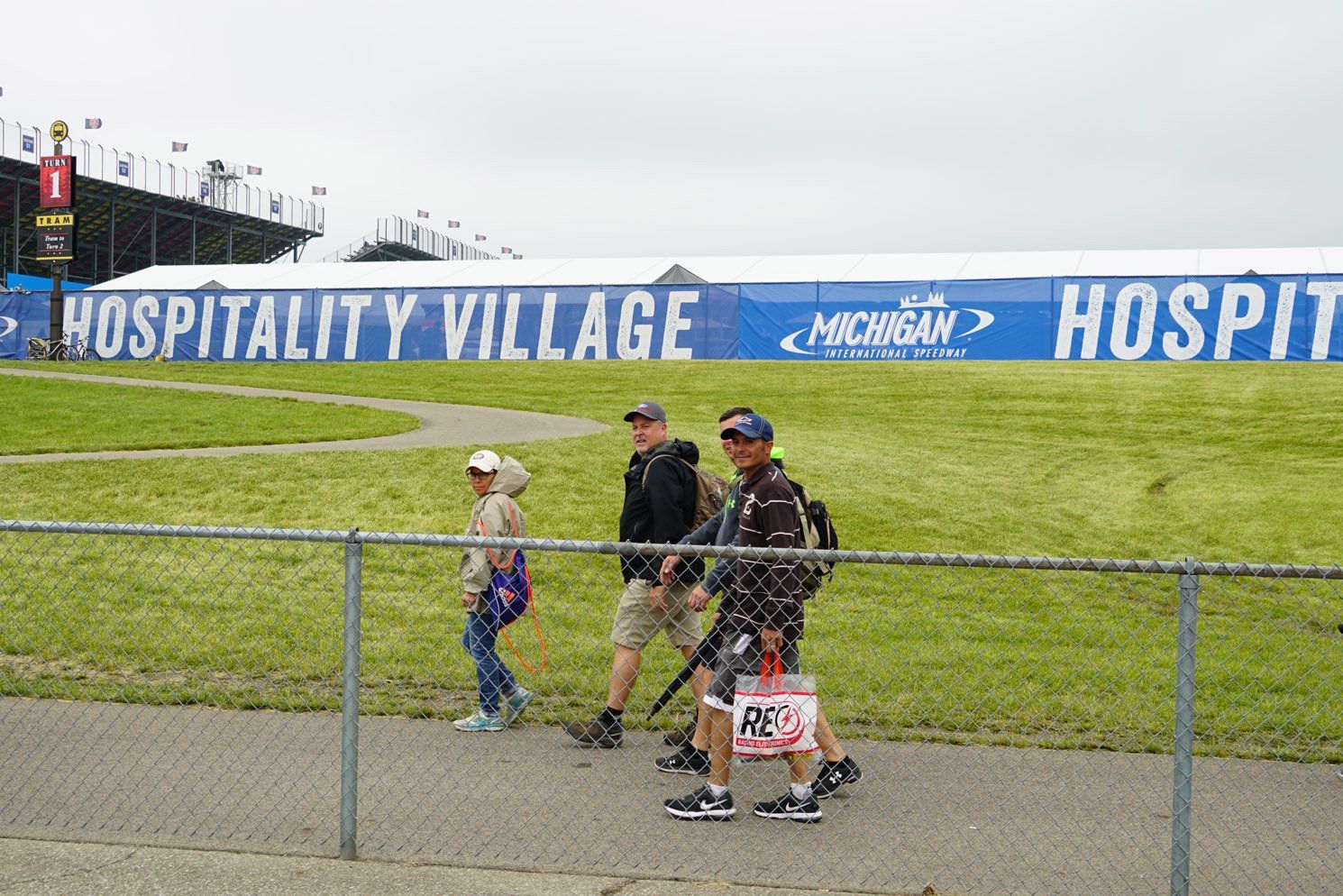 People walking in front of a sign that says hospitality village