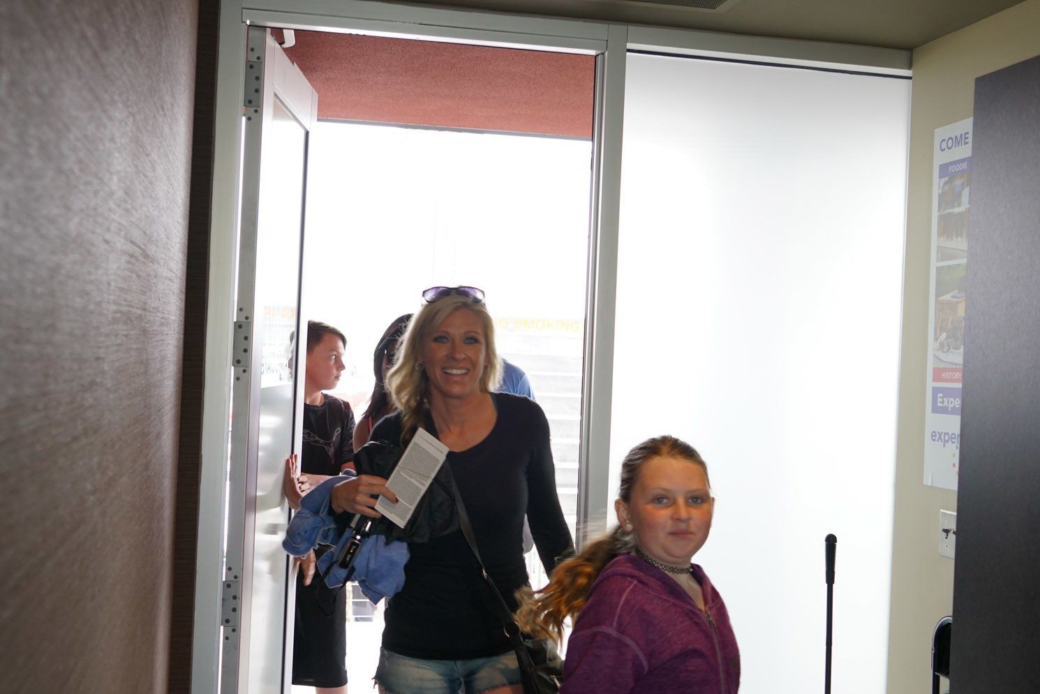 A woman and a girl are walking out of a doorway