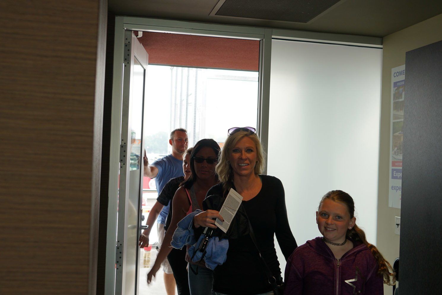 A group of people are walking through a doorway