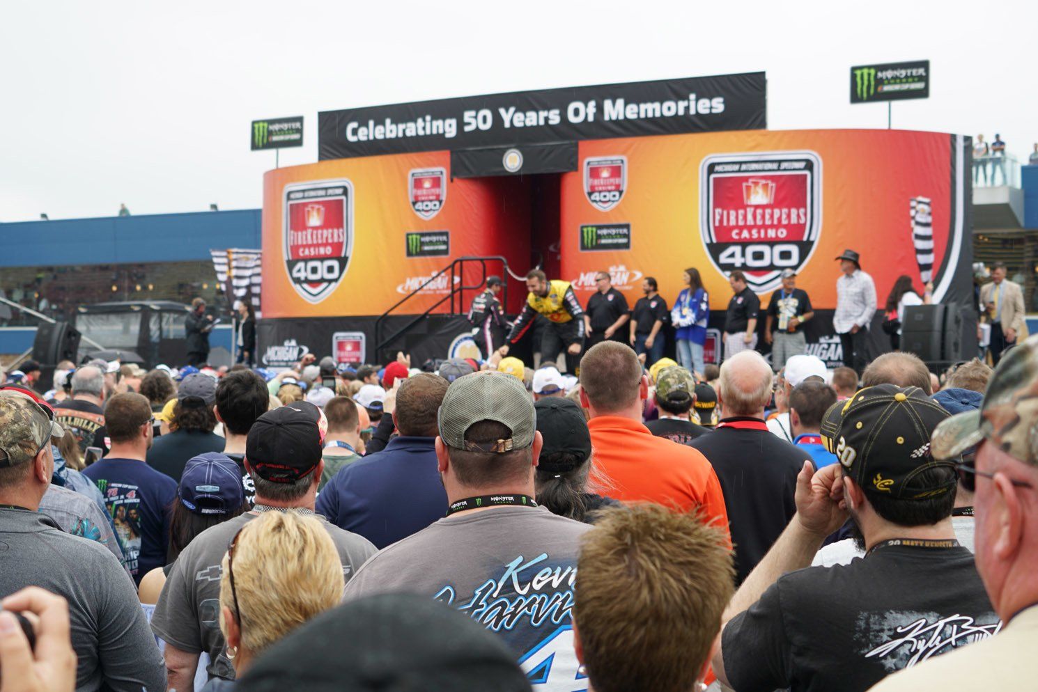 A crowd of people gathered in front of a stage that says celebrating 50 years of memories