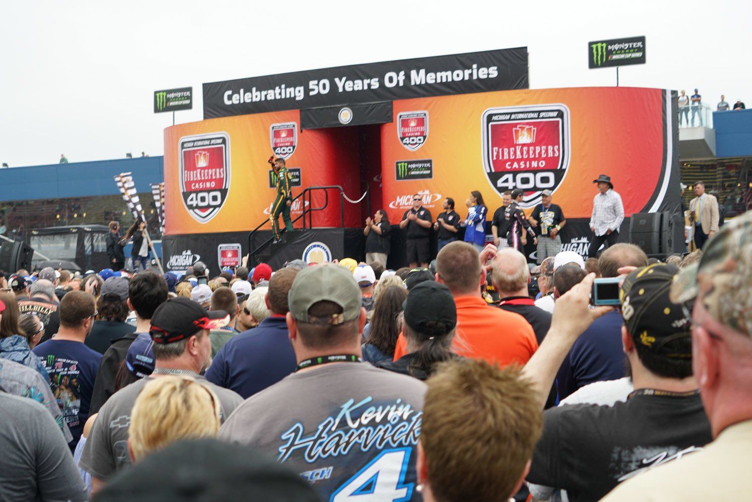 A crowd of people gathered in front of a stage that says celebrating 50 years of memories