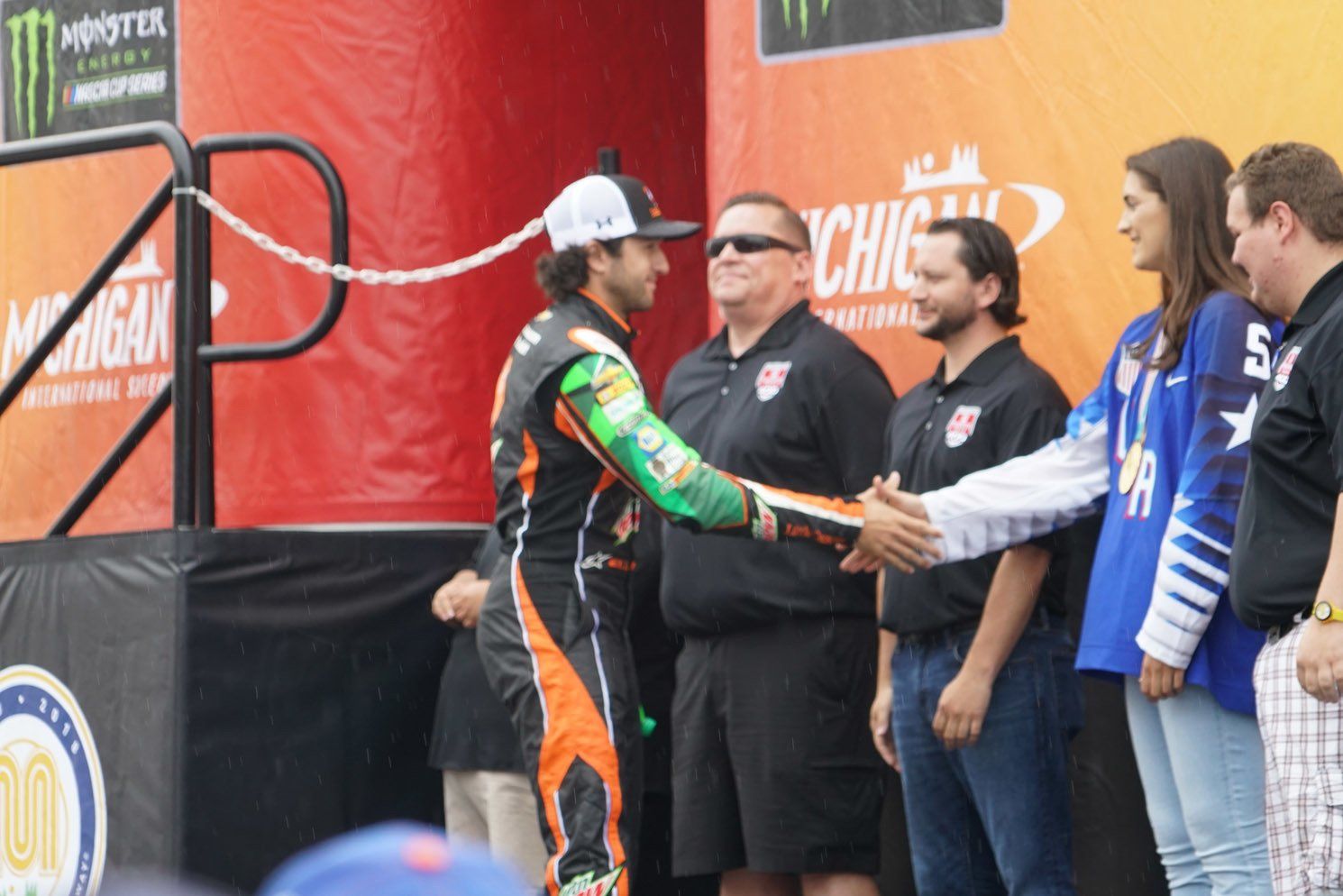 A group of people standing in front of a monster energy sign