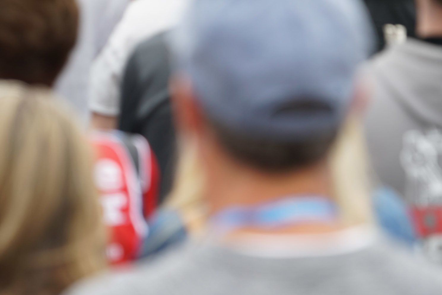 A blurry picture of a man 's back with a hat on.