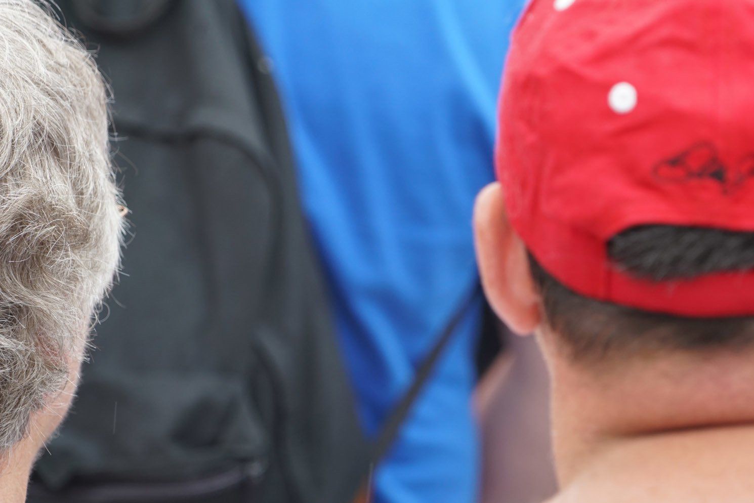 A man wearing a red hat is looking at another man