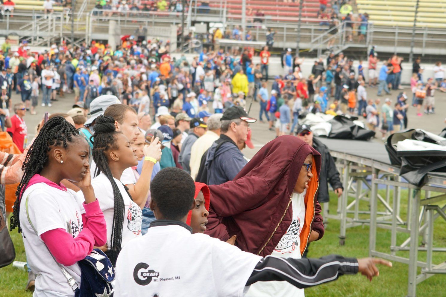 A group of people are standing on a field in front of a crowd.
