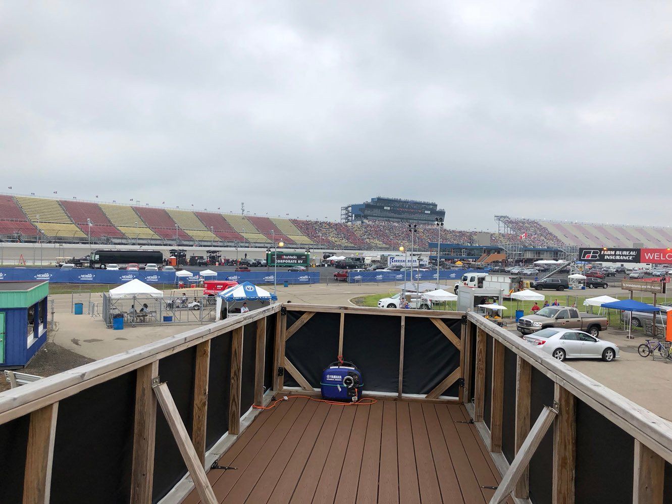 A view of a race track from a wooden deck.