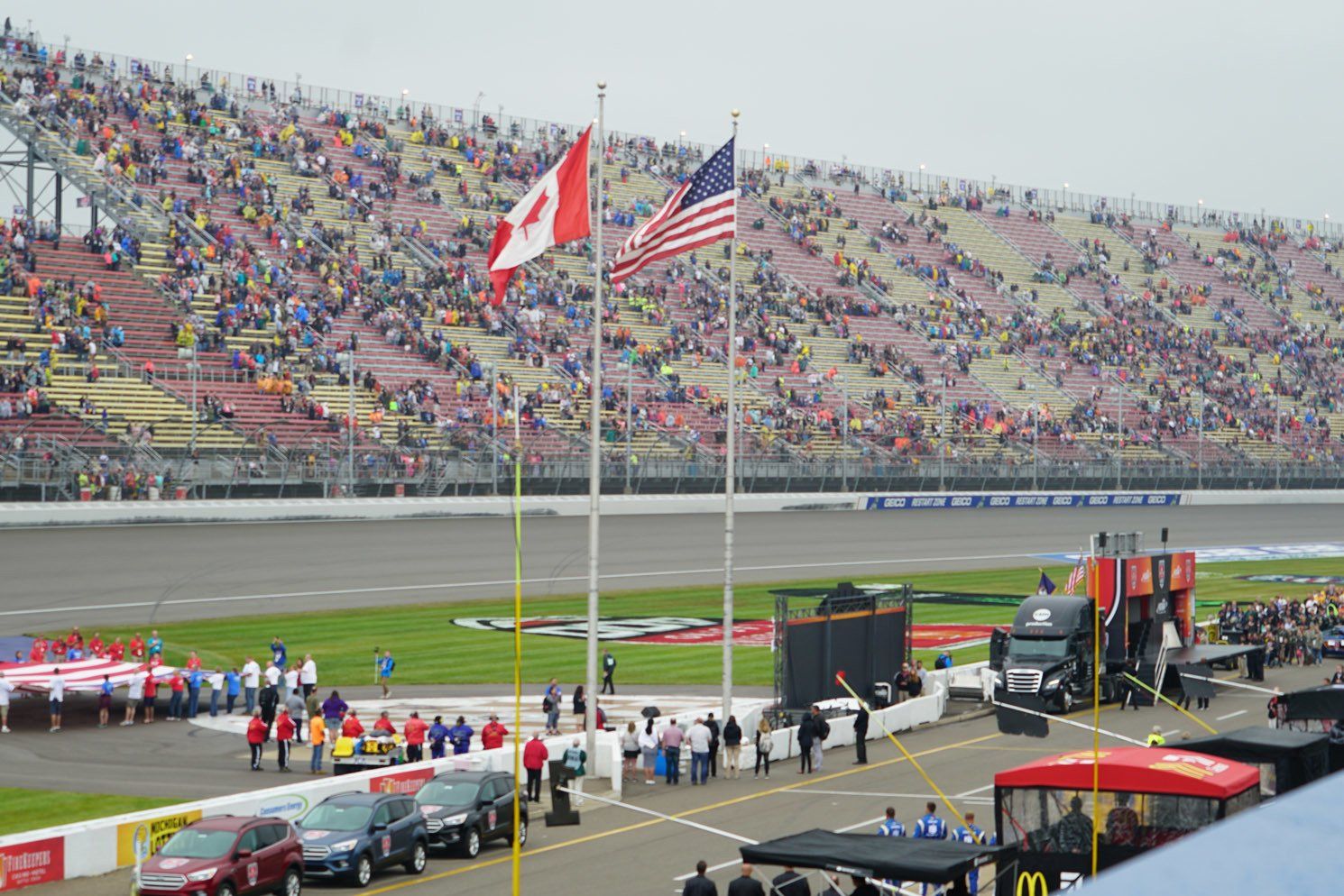 A race track with cars parked on the side and flags flying