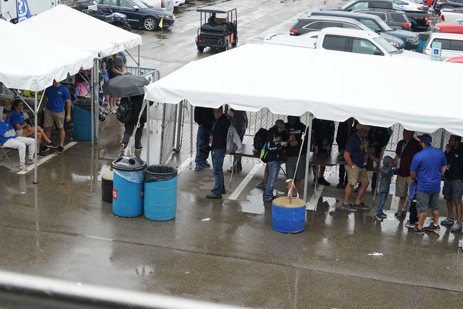 A group of people standing under tents in a parking lot