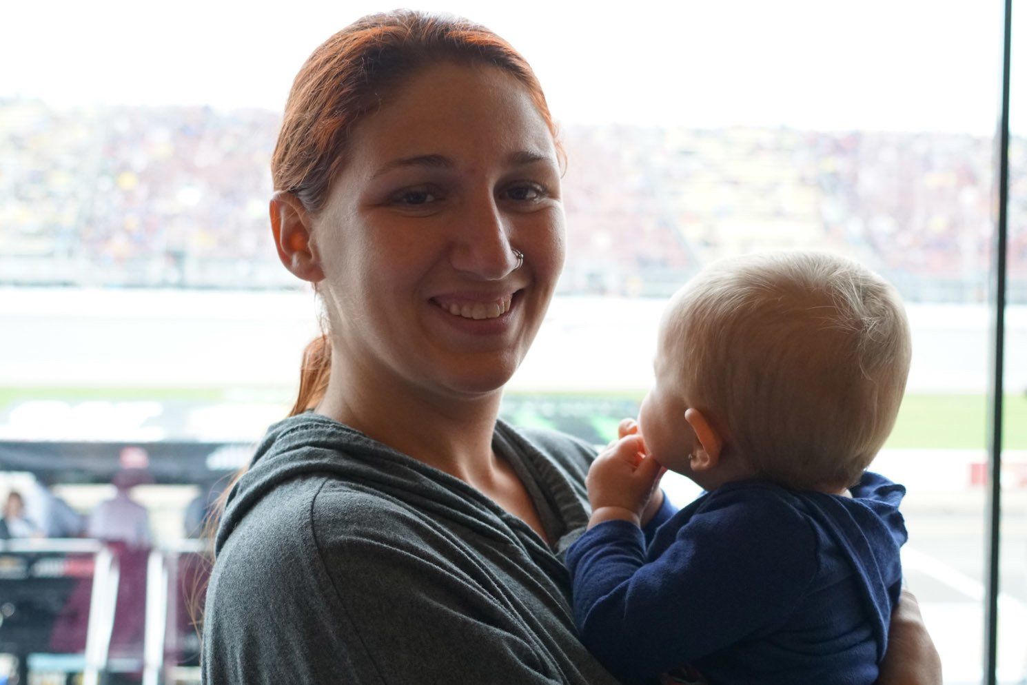 A woman is holding a baby in her arms and smiling