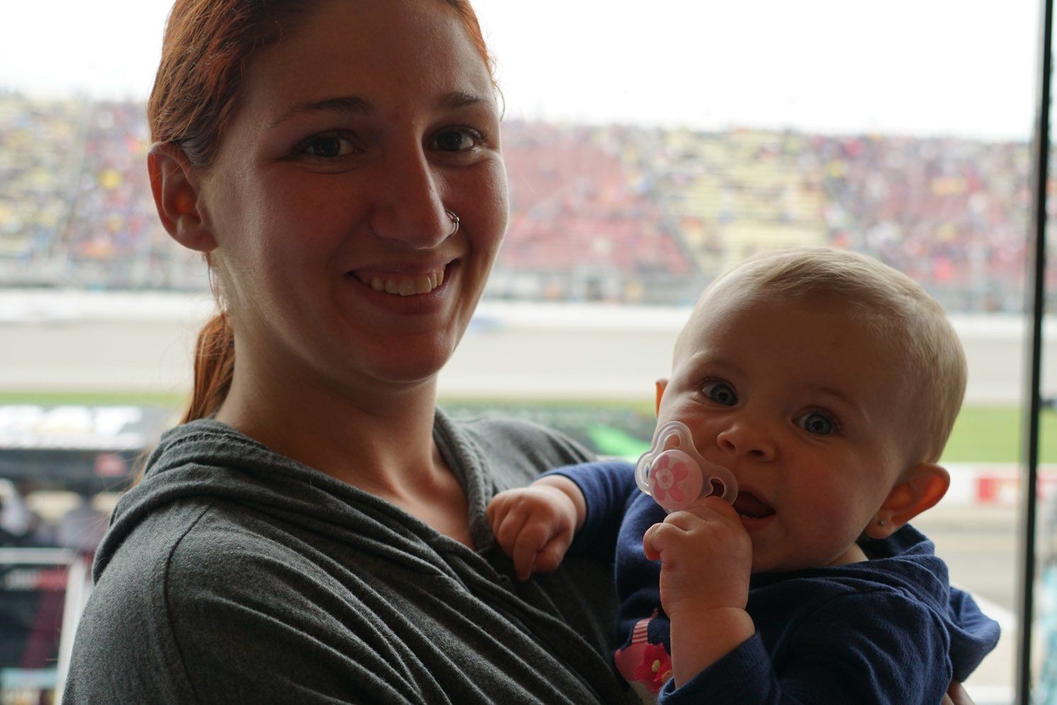 A woman is holding a baby in her arms and smiling.
