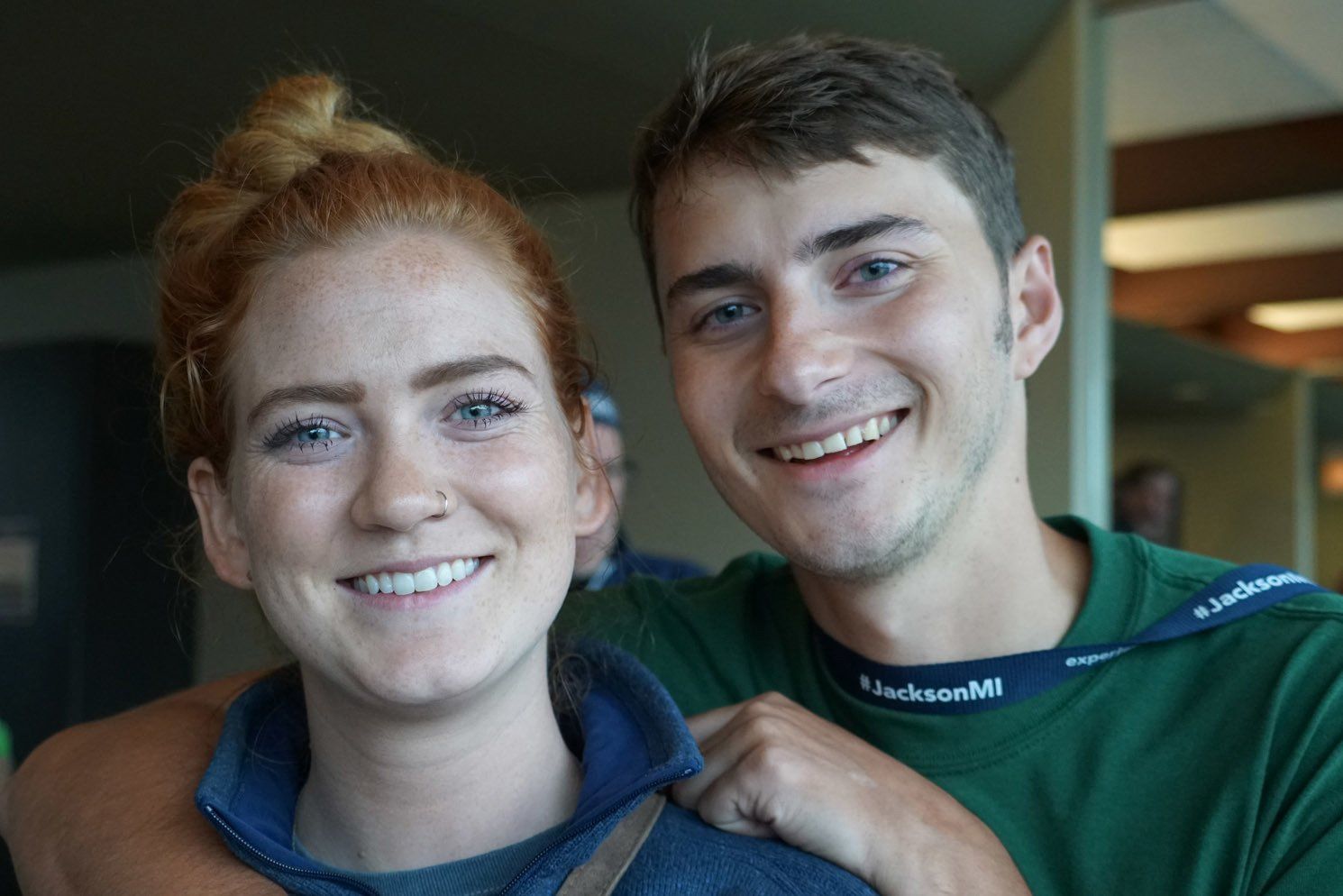 A man and a woman are posing for a picture and smiling for the camera.