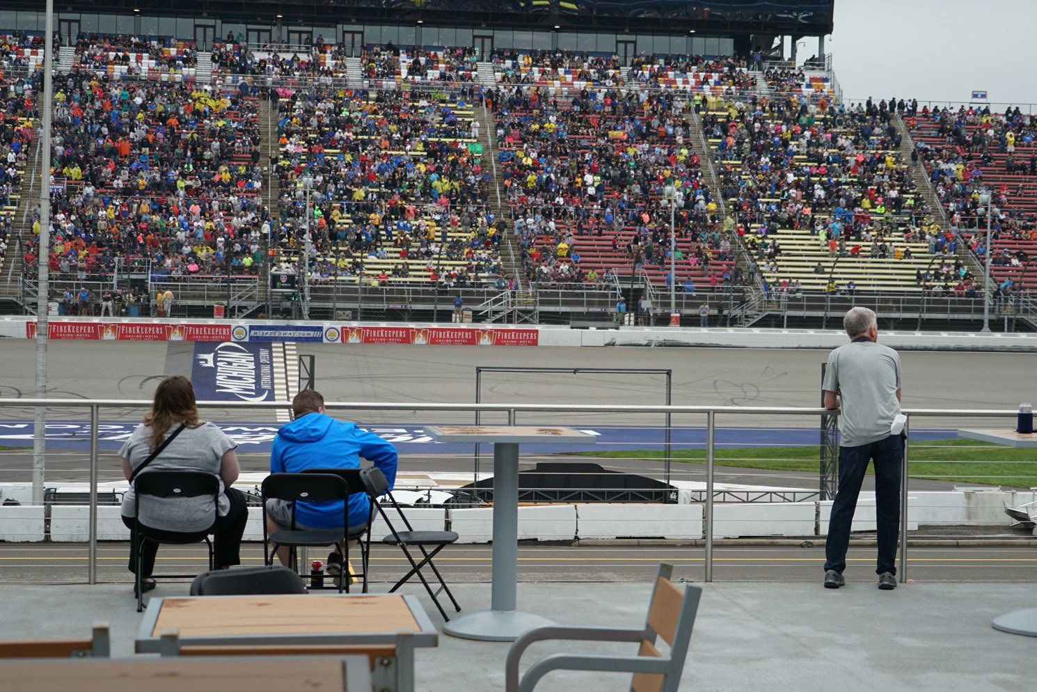 A group of people are watching a race at a race track.