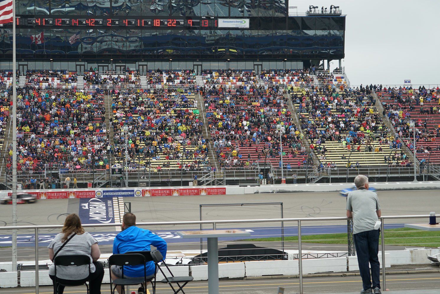 A crowd of people are watching a race at a race track