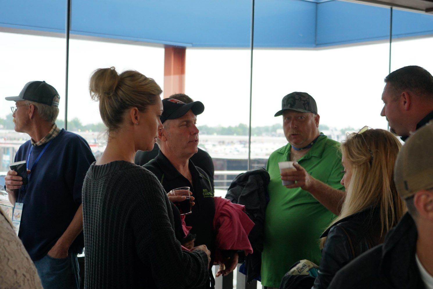 A group of people standing in front of a window talking