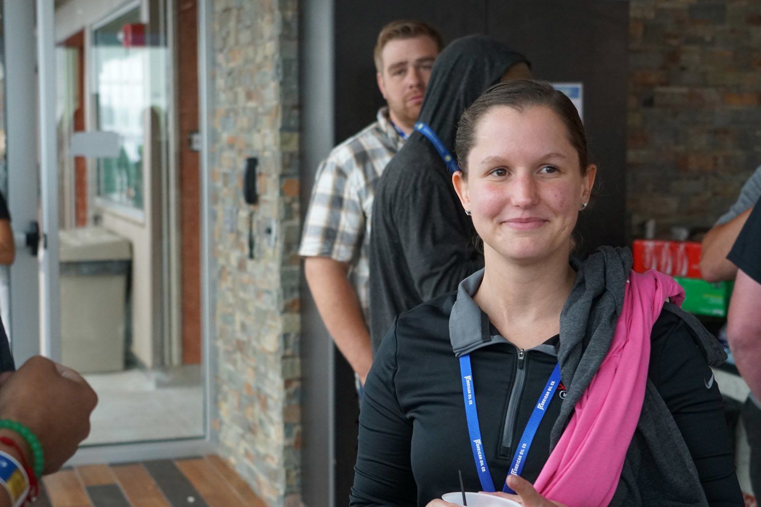 A woman with a lanyard around her neck is smiling
