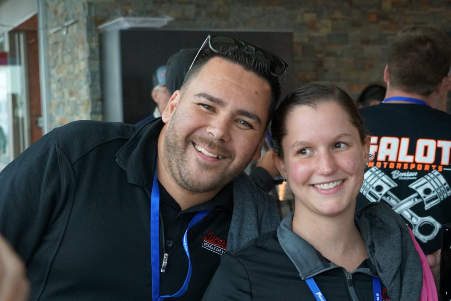 A man and a woman are posing for a picture and the man is wearing a shirt that says alot