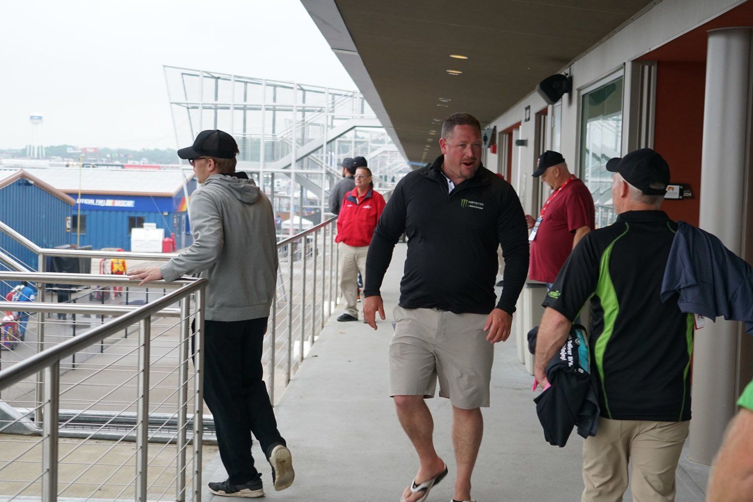 A group of men are walking down a hallway talking to each other