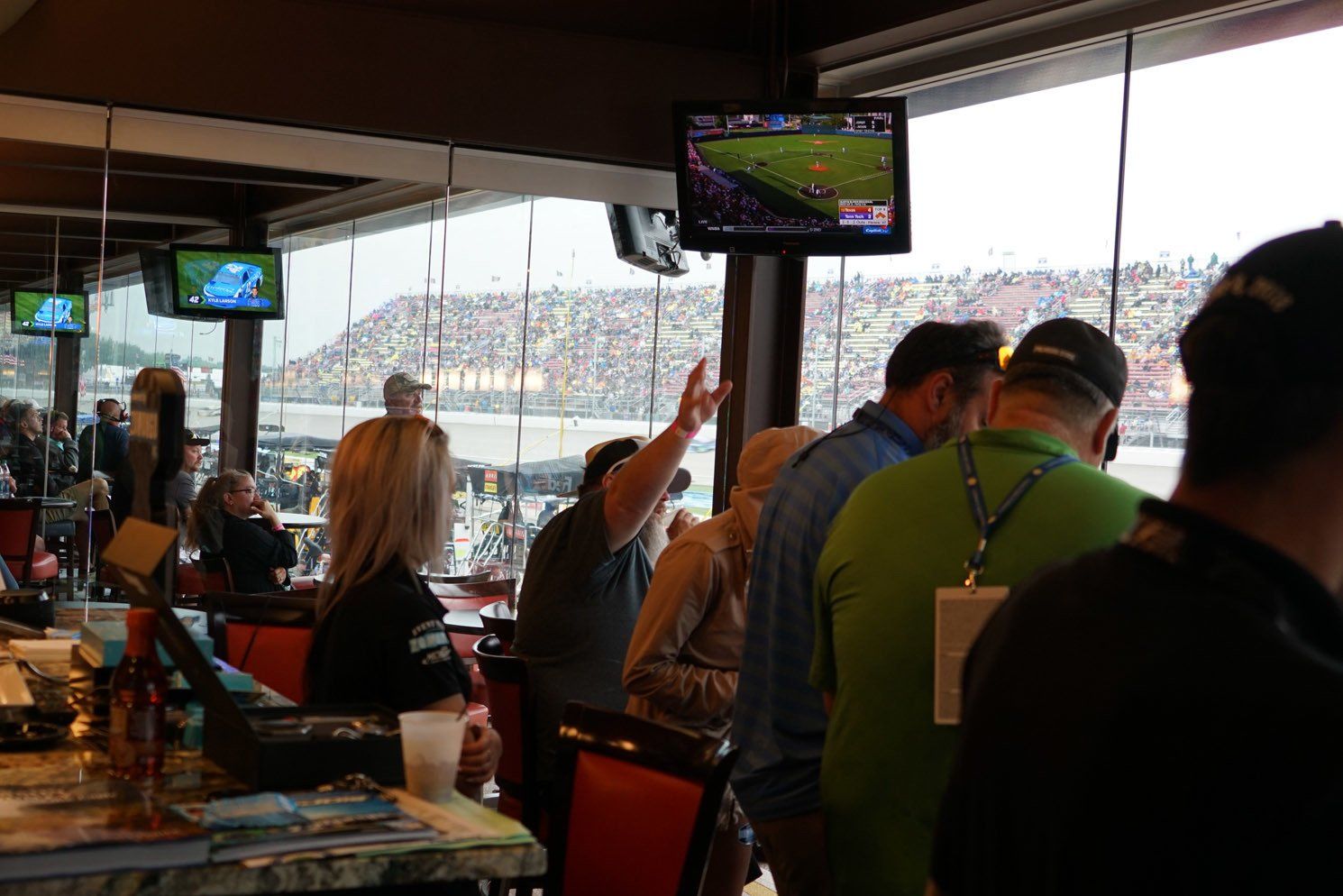 A group of people are sitting in a restaurant watching a football game.