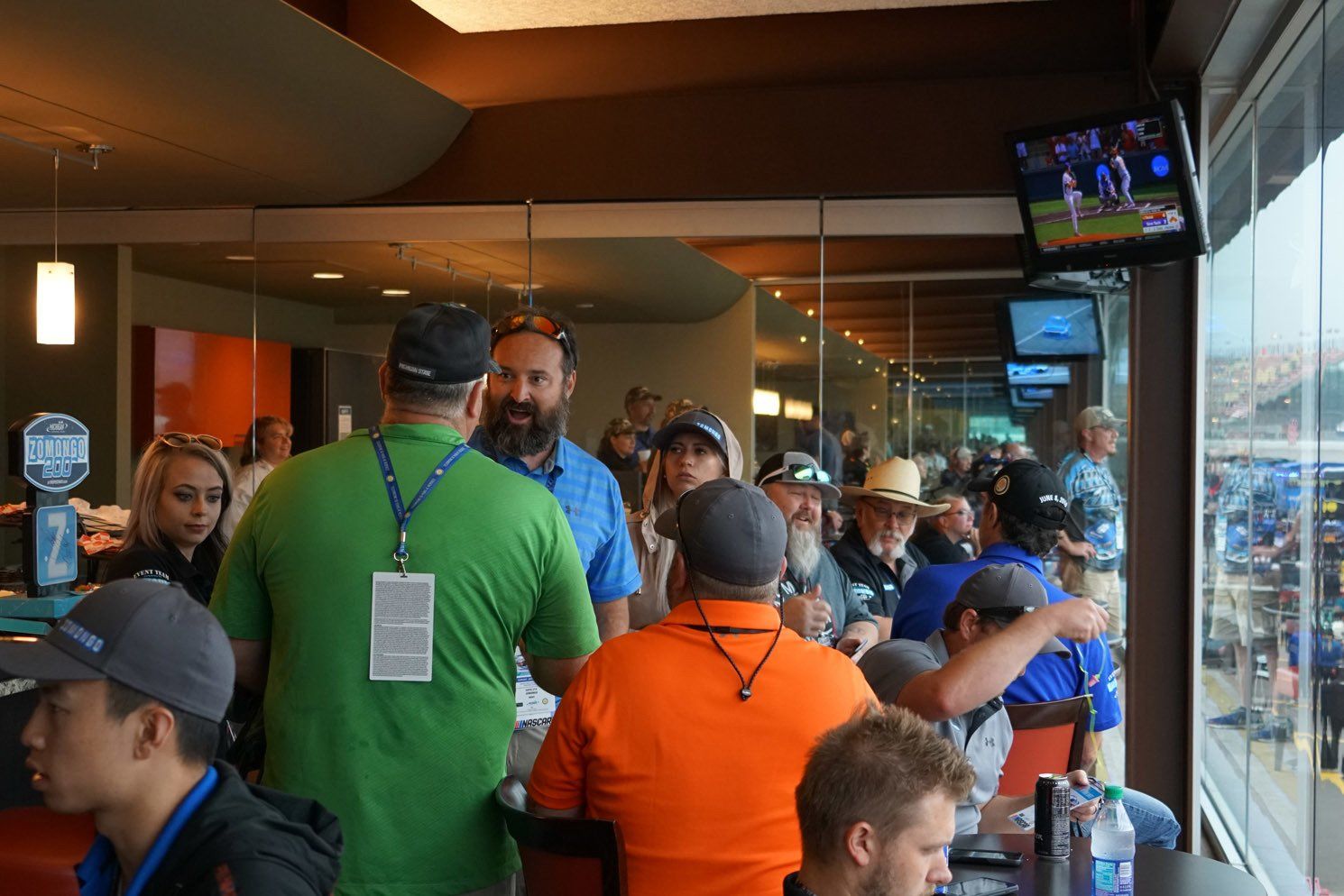 A group of people are gathered in a room with a large window.