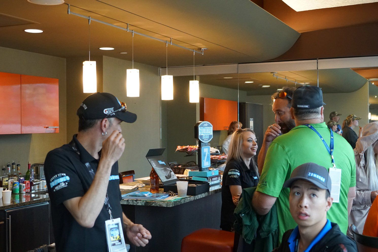 A group of people are standing around a counter in a restaurant.