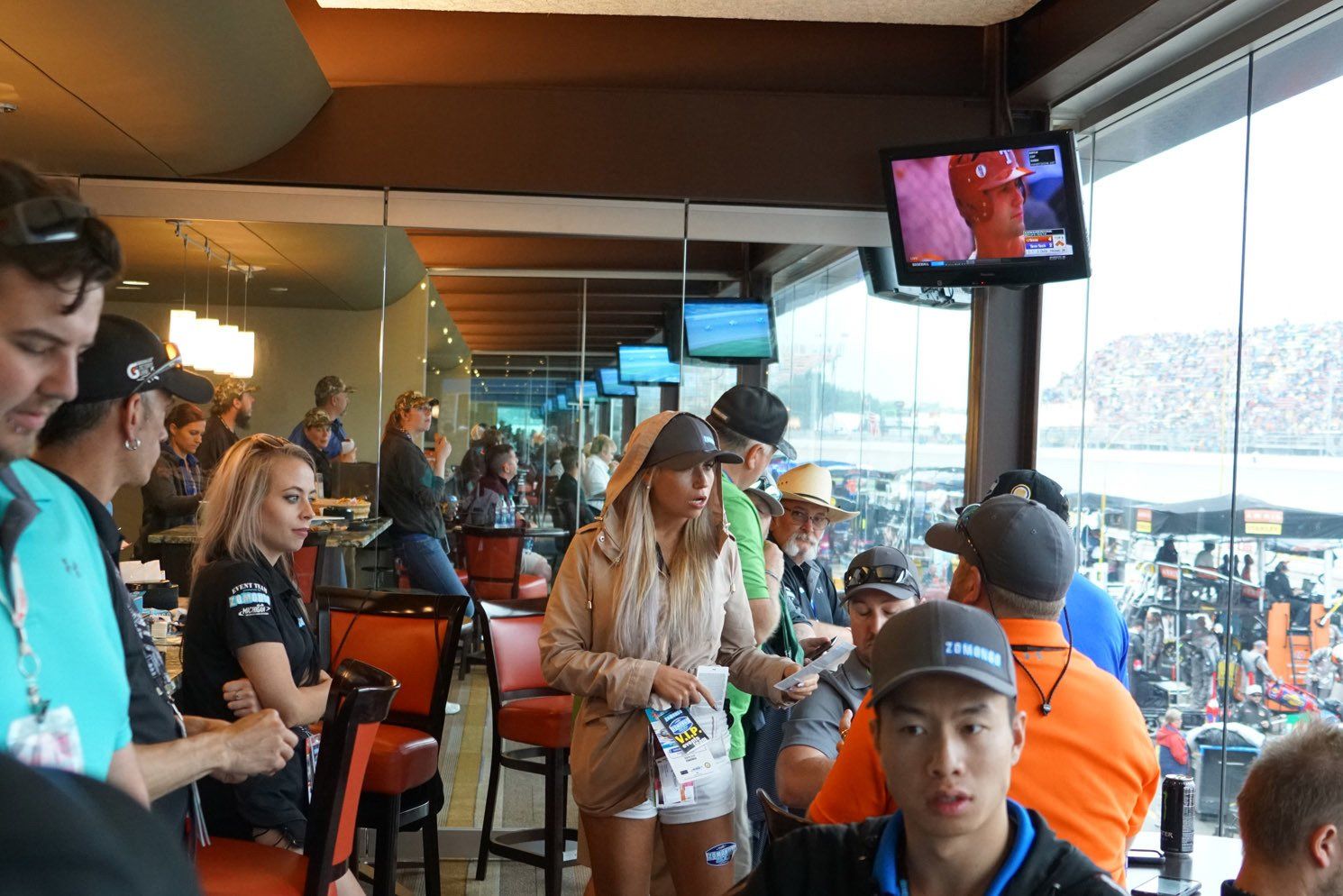 A group of people are sitting in a restaurant watching a race
