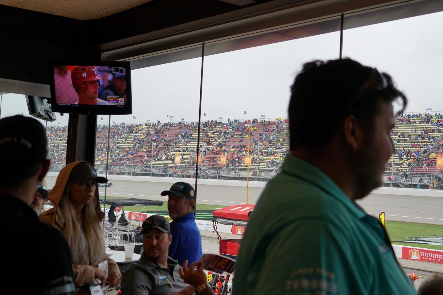 A group of people are sitting in a restaurant watching a race.