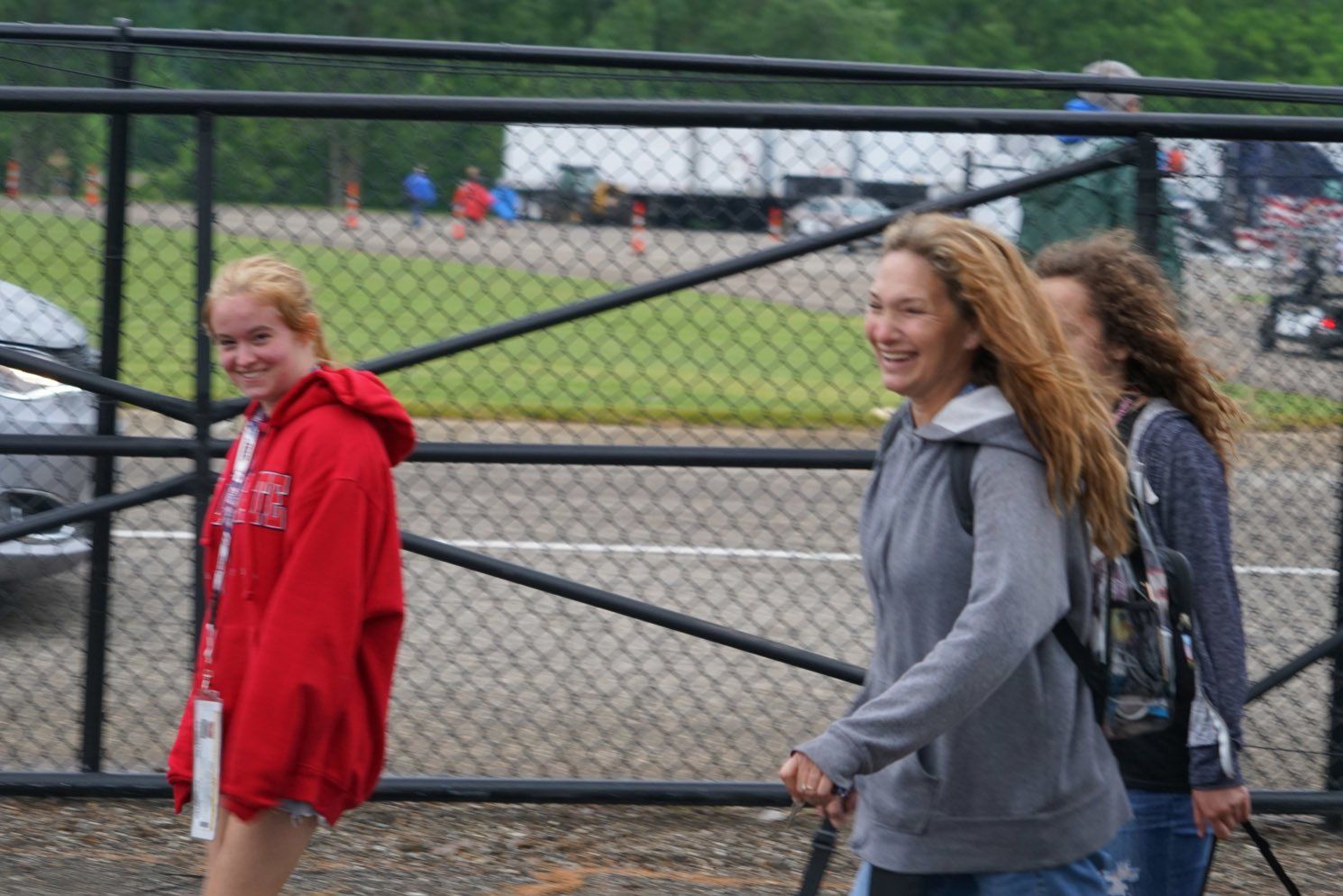 A girl in a red hoodie is walking with two other girls