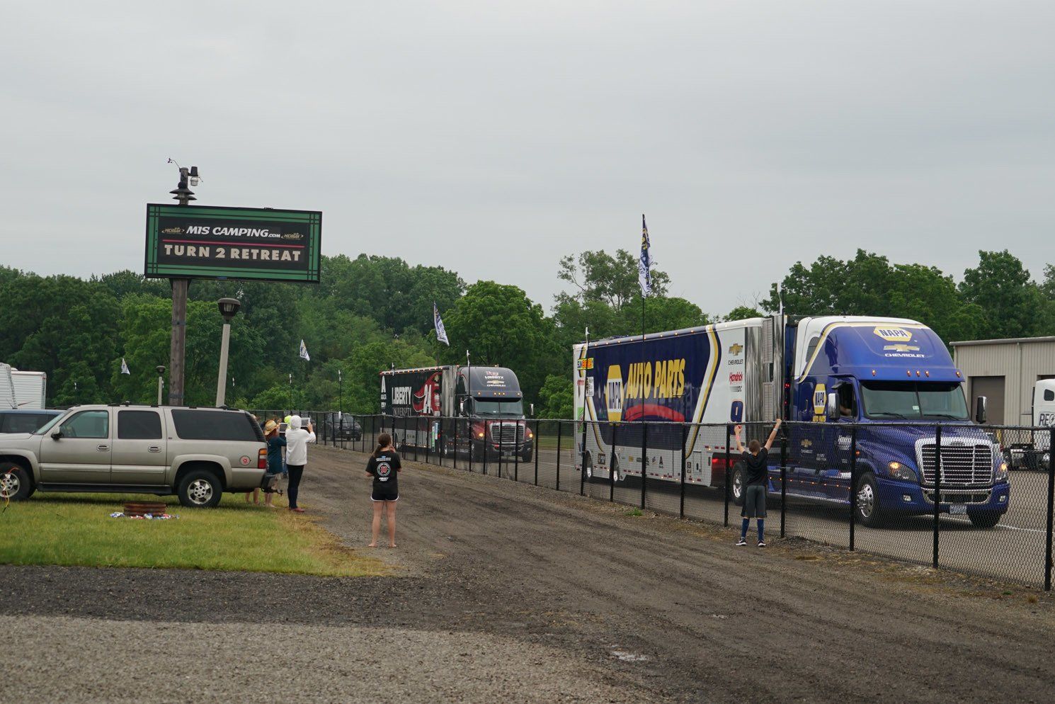 A row of moving trucks are parked in a parking lot